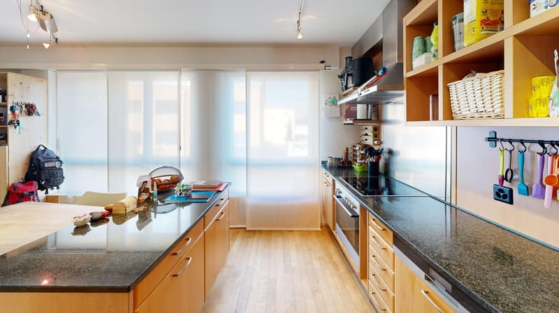 modern kitchen with granite countertops, wooden cabinets, gas stove, oven, dishwasher, hanging utensils, large windows