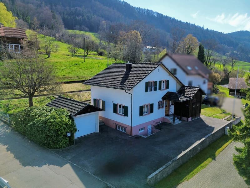 Detached house, two garages, driveway, green surroundings, mountain view