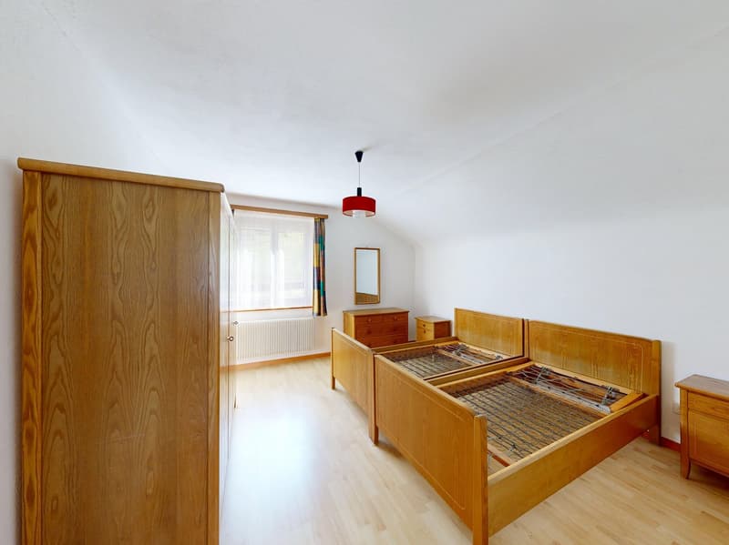Bedroom with wooden beds, wooden wardrobe, wooden cabinet, mirror, radiator, lamp