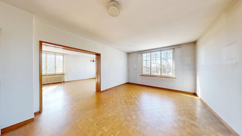 empty room, wooden parquet floor, white walls, two windows, wooden door frame