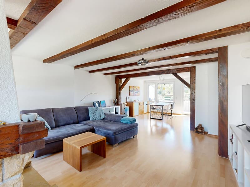 wooden beams, fireplace, blue sofa, wooden coffee table, wooden floor, white walls