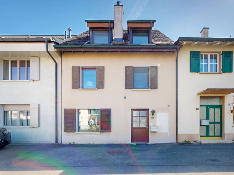 3 story house, beige exterior, brown shutters, brown door, windows, chimney, car parked in front