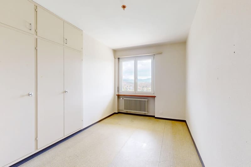 empty room, white walls, white floor, large window, white built-in wardrobes, white radiator
