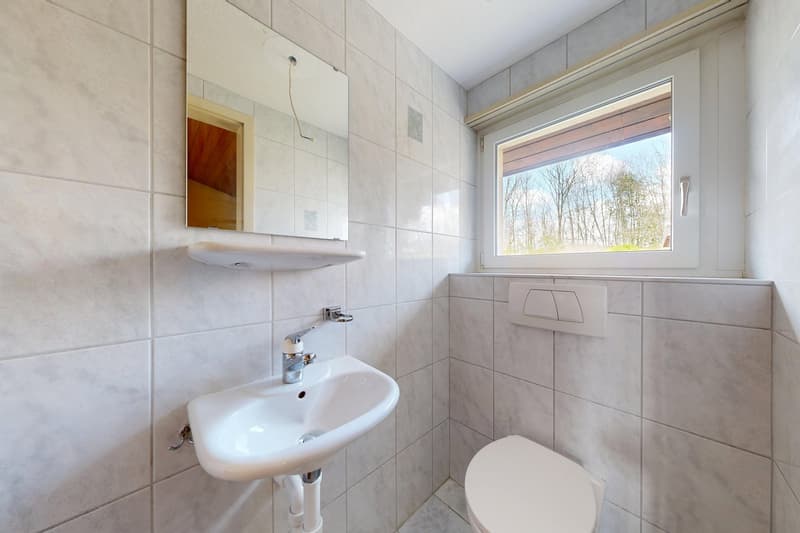 Bathroom with white tiles, sink, mirror, toilet, window