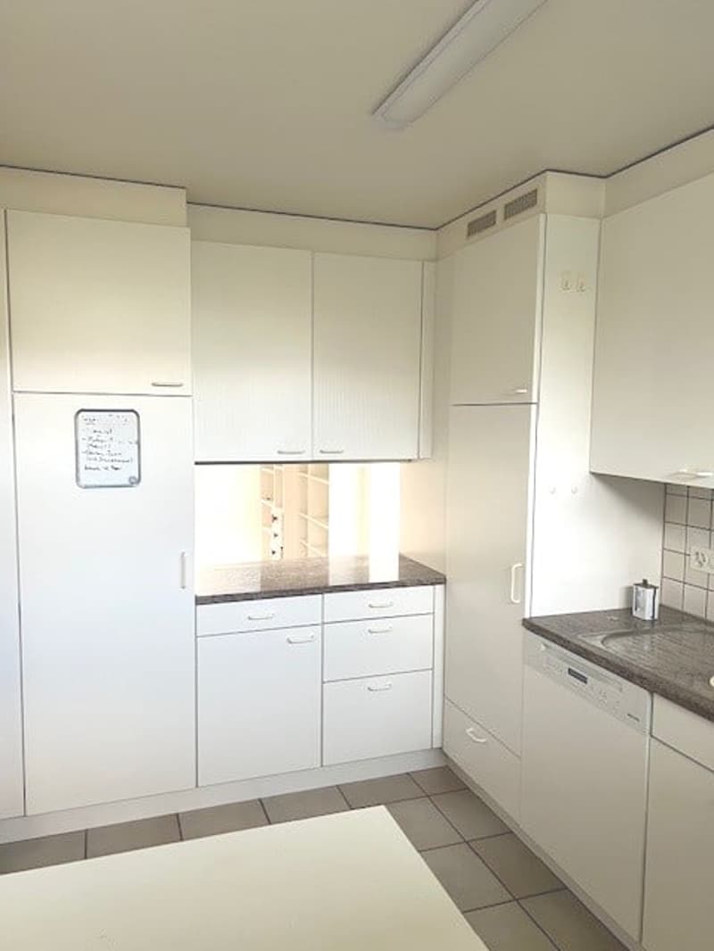 Modern kitchen, white cabinets, tiled floor, granite countertop, dishwasher, and private washing machine