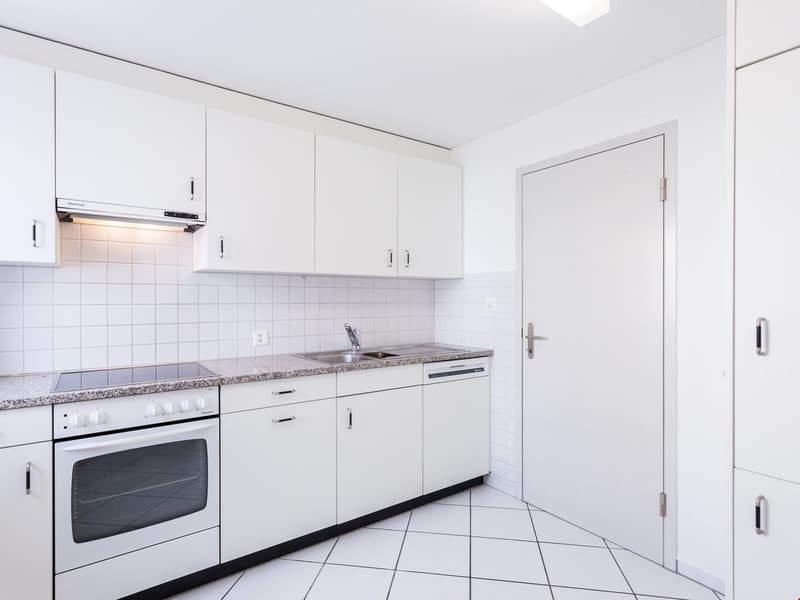 modern kitchen with white cabinets, granite countertops, integrated dishwasher, electric stove, and sink with faucet