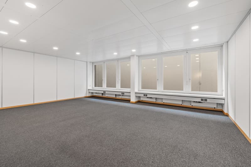 empty room, white walls, gray floor, three large windows, recessed lighting