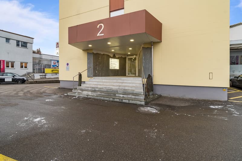 Apartment building, building number 2, main entrance, parking space, concrete steps, tiled floor, modern yellow walls, nearby car
