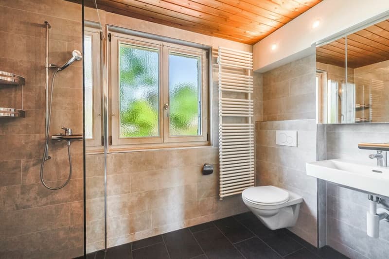 Badezimmer im OG mit Dusche, WC, Lavabo, Handtuchradiator und Fenster