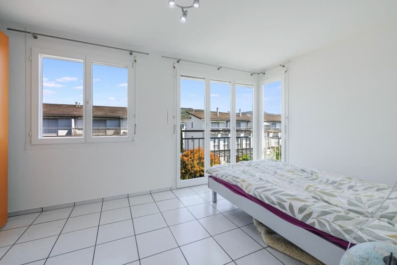 Zimmer mit grossen Fenstern und französischem Balkon für viel Tageslicht