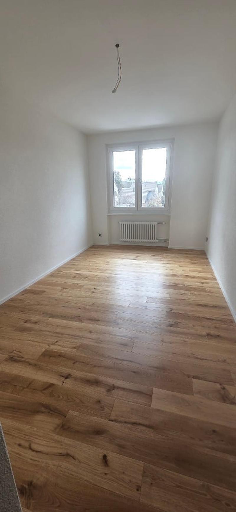 Empty room, hardwood floor, white walls, large window