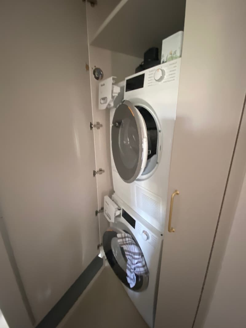 Stacked washer and dryer unit, white appliances, control panel