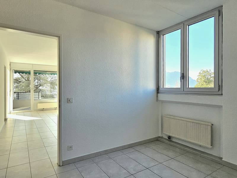 empty room, white walls, tile floor, windows with balcony