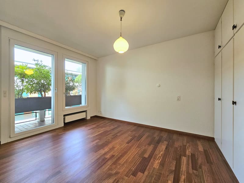 Wooden floor, sliding glass doors, balcony, pendant light, white walls, built-in cabinets
