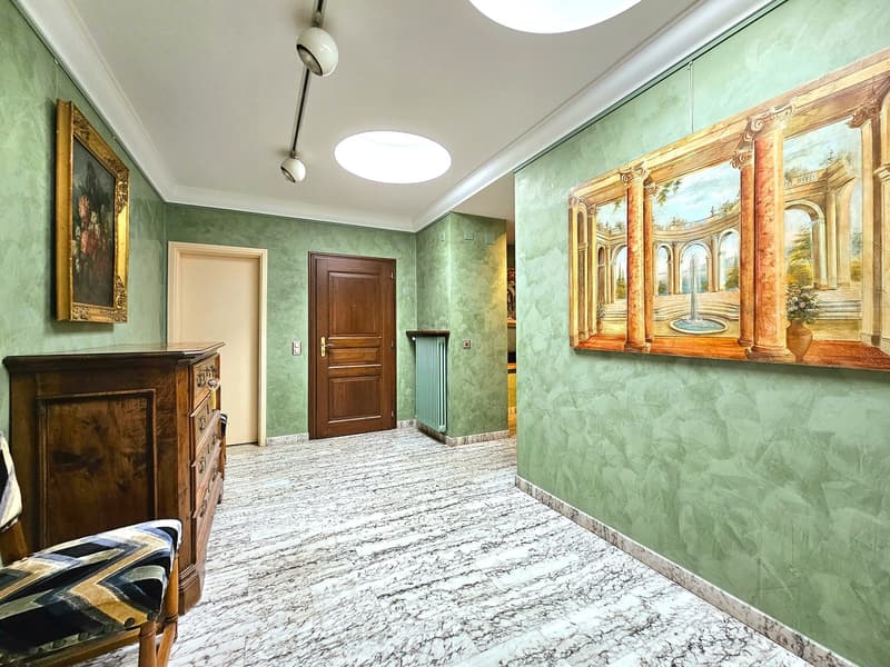 green walls, two lamps, wooden cabinet, white marble floor, framed painting, wooden door
