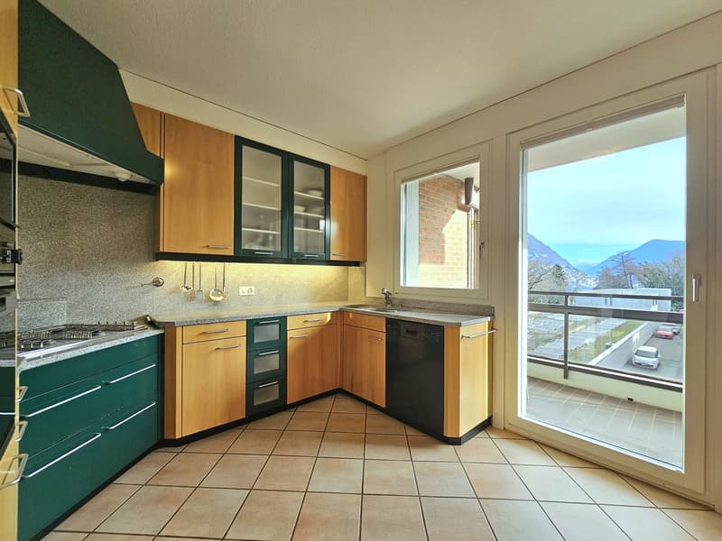 Wooden cabinets, granite countertops, stainless steel appliances, dishwasher, sliding glass door to balcony