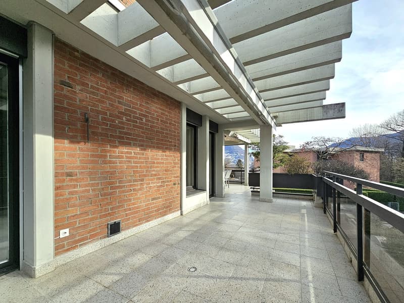 tiled floor, brick wall, glass door, metal railing, pergola roof