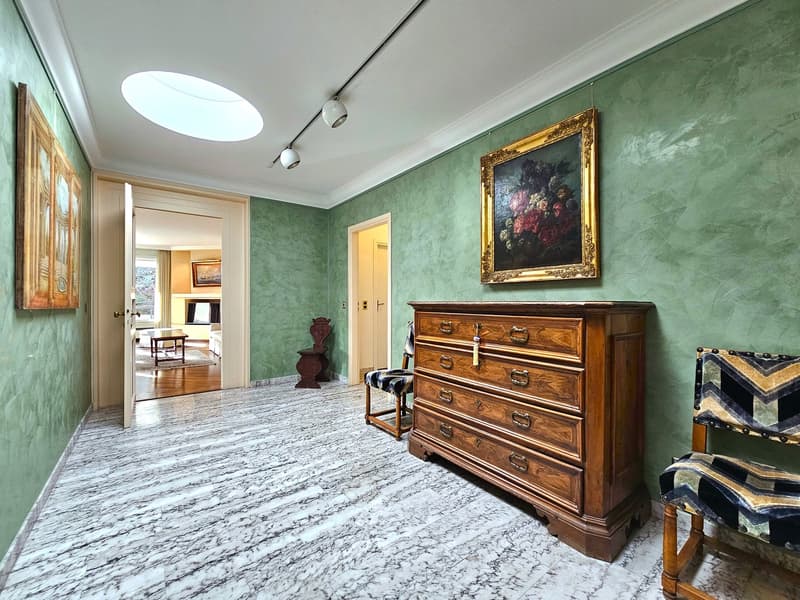 Marble floors, green walls, large picture frame, wooden dresser, wooden chair