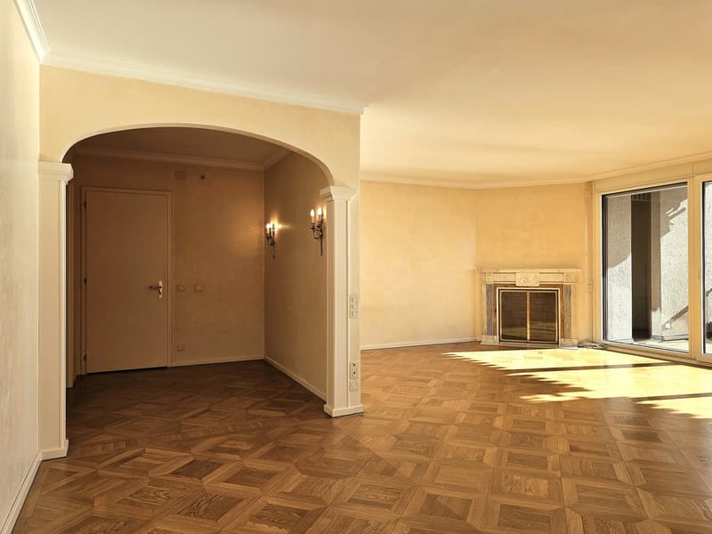 open layout, hardwood floor, arched doorway, glass walls, fireplace, light fixtures