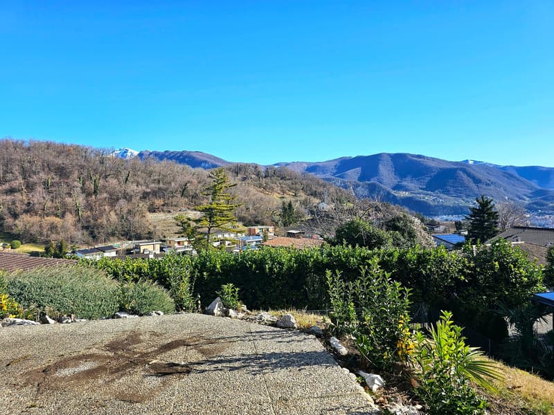 gravel pathway, shrubs, houses, mountains