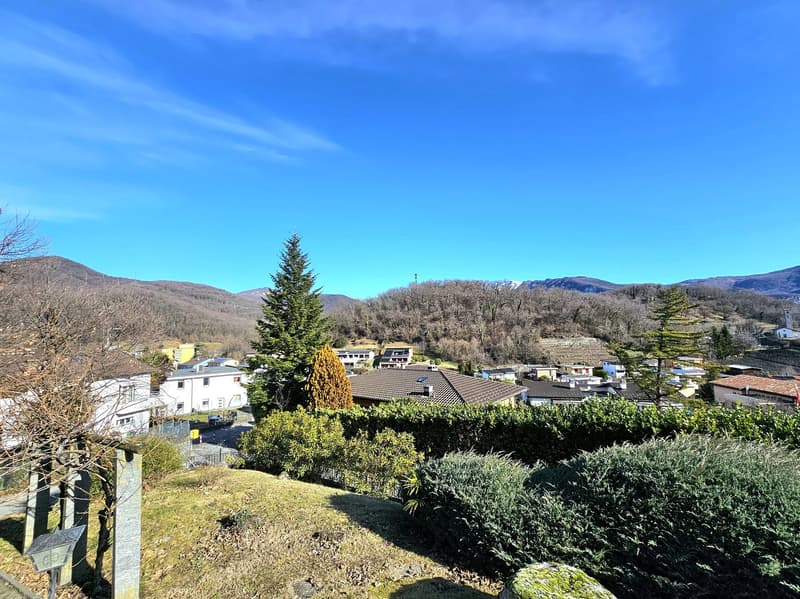 a beautiful landscape with hills and mountains, trees, houses and a clear blue sky