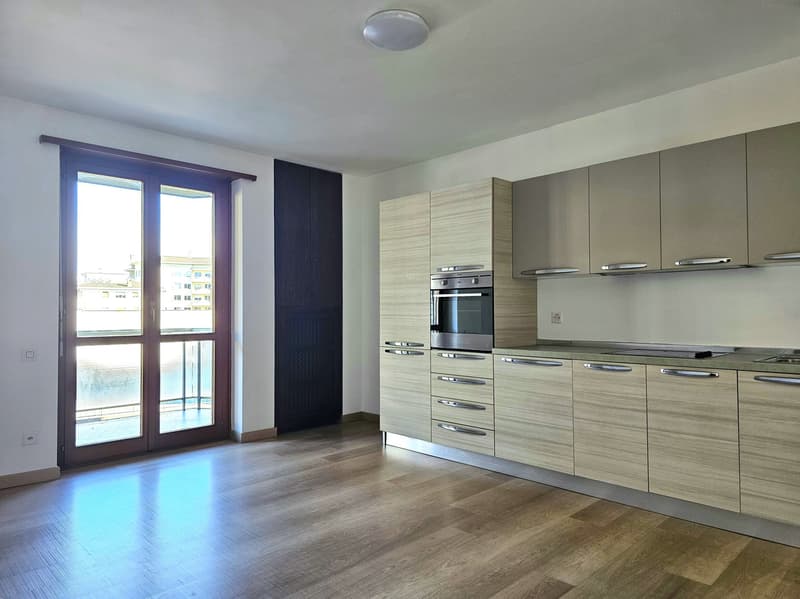 modern kitchen with wooden floor, large windows, balcony, built-in oven, cabinets, countertop
