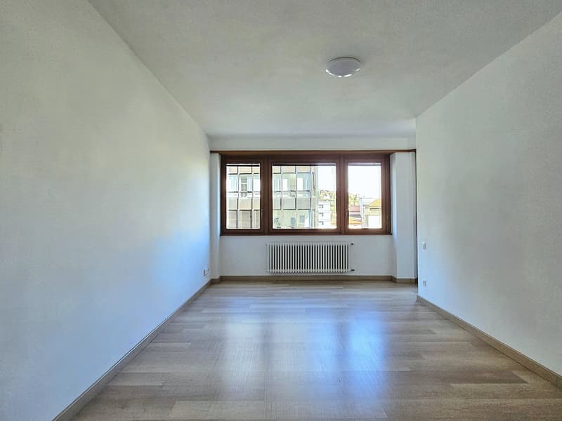 empty room, white walls, wooden floor, large window, radiator