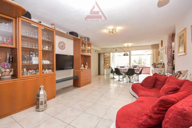white tiles, modern furniture, red couches, television, cupboard, dining table with chairs