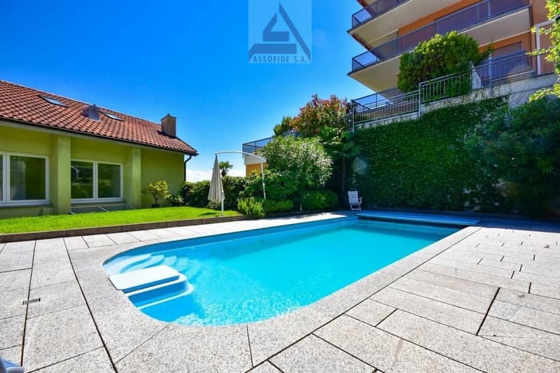 2 story house, swimming pool, paved area, plants and shrubs, raised ground floor