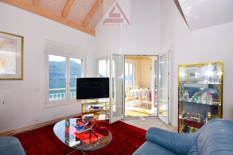 large glass windows, red carpet, modern style, flatscreen TV, glass table, sofa, glass door with balcony