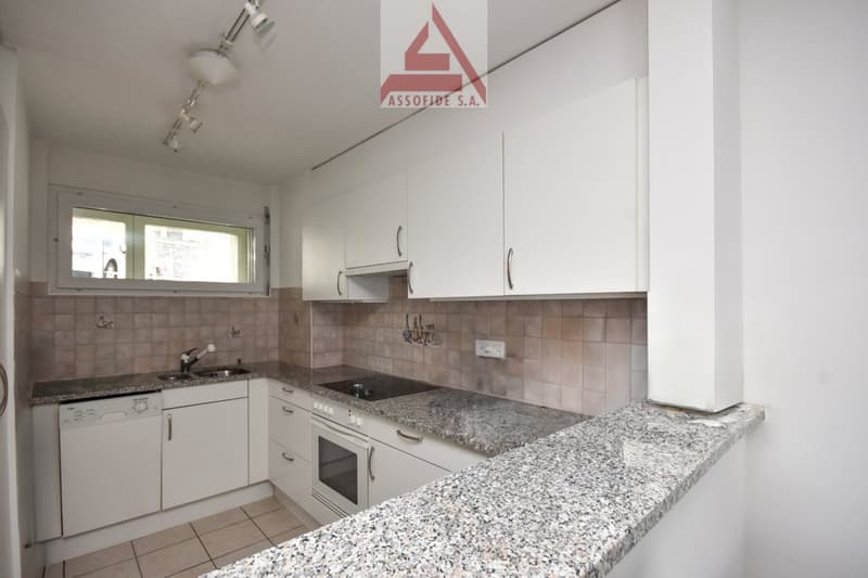 white cabinets, granite countertops, white appliances, tiled floor, power outlet, window with view
