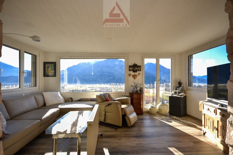 leather sofa, relax chair, coffee table, wooden floor, large windows, exterior mountains
