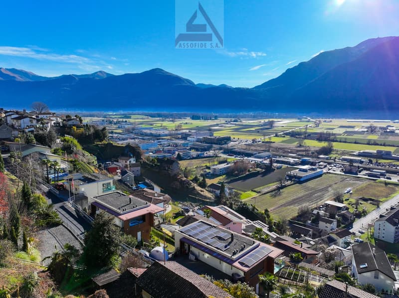 elevated area with multiple houses, solar panels, mountain backdrop