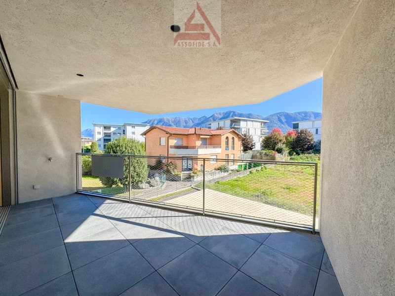 Balcony with floor tiles, steel railing, distant view of a house and mountains