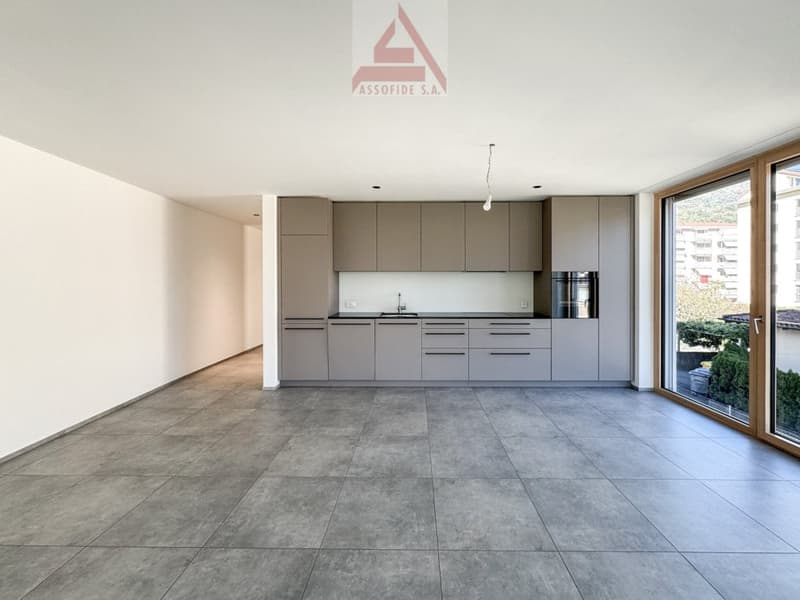 open plan kitchen with modern cabinets and integrated appliances, large windows, tiled flooring, no furniture