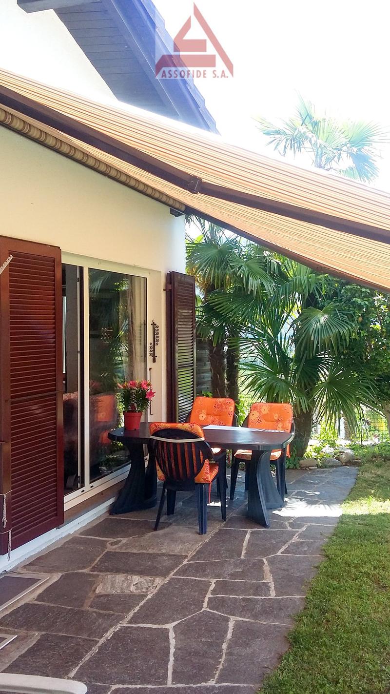 patio, table and chairs, flowers, shaded by awning, outdoor plants