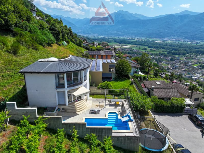 Modern house with a curved roof, swimming pool, solar panels, terrace, located on a hillside