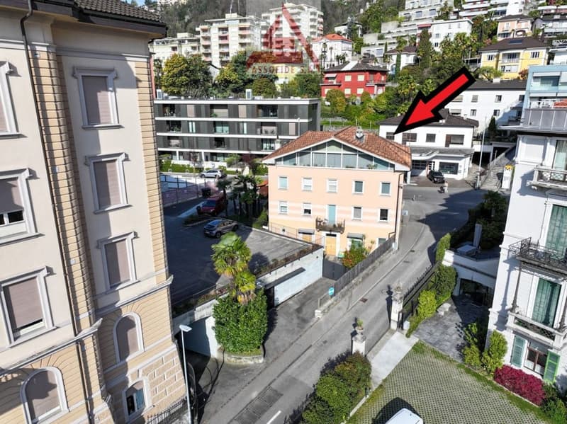 4 story house, beige facade, multiple windows, red roof, parking place, surrounded by buildings