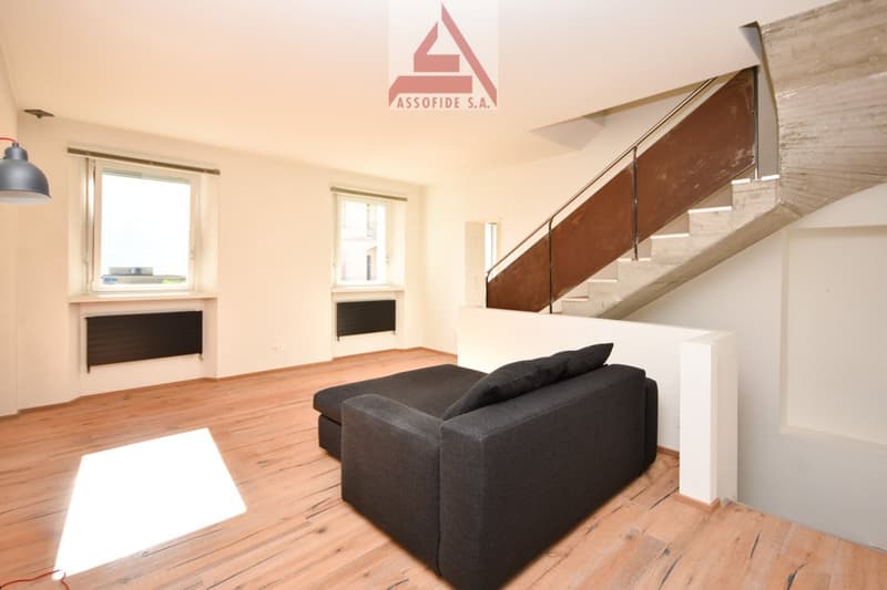 empty, wooden floors, two large windows, sofa, stairs to the upper floor