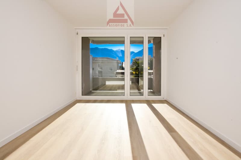 empty room with sliding glass doors leading to a balcony with mountains view