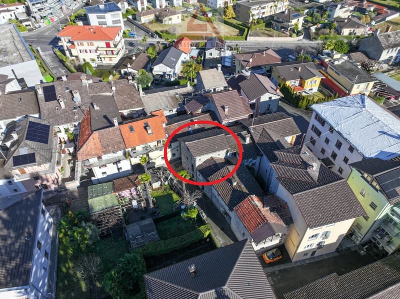 House surrounded by other houses in a neighborhood with solar panels on some roofs.