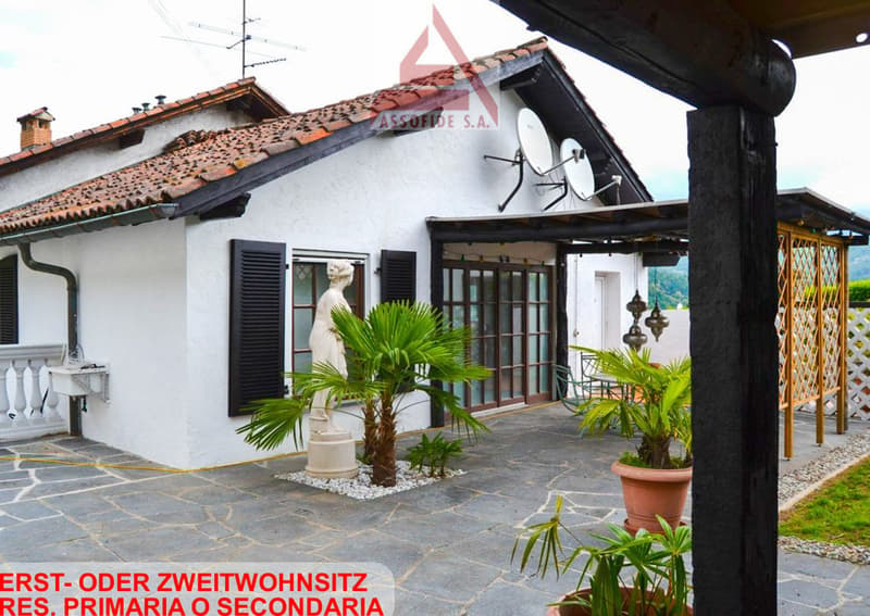 white stucco house, red tiled roof, brown shutters, small terrace, garden, statue