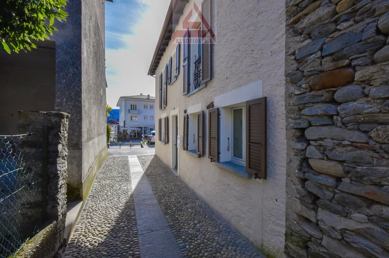 stone wall building, wooden shutters, stone path, fenced area