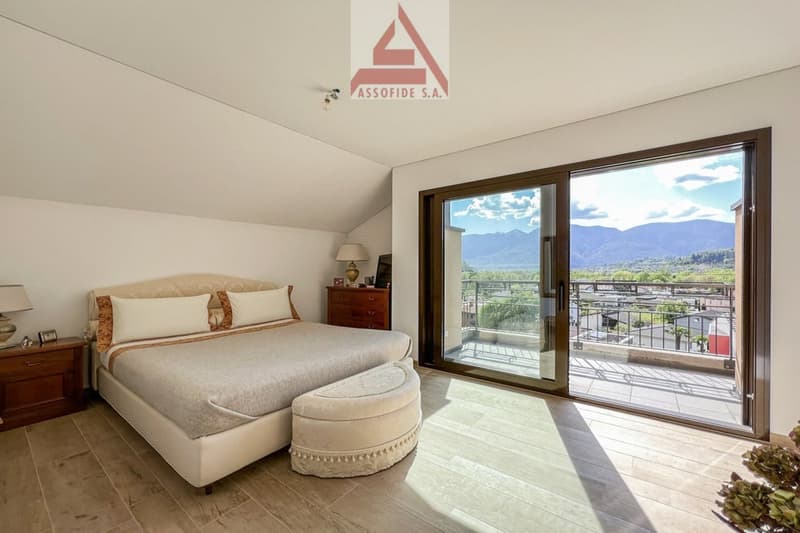 large bed, white bedding, 2 nightstands, lamp, wooden cabinet, sliding glass door, balcony, view of mountains