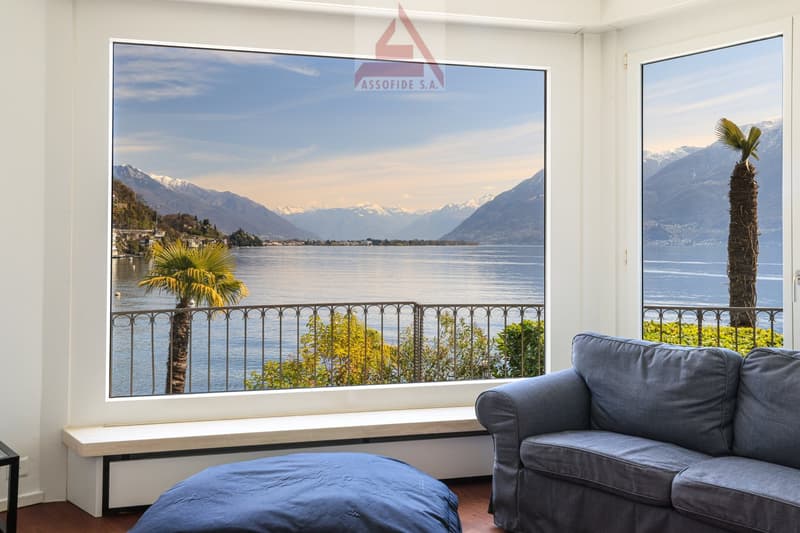 large windows, balcony, couch, ottoman, lake view, mountains