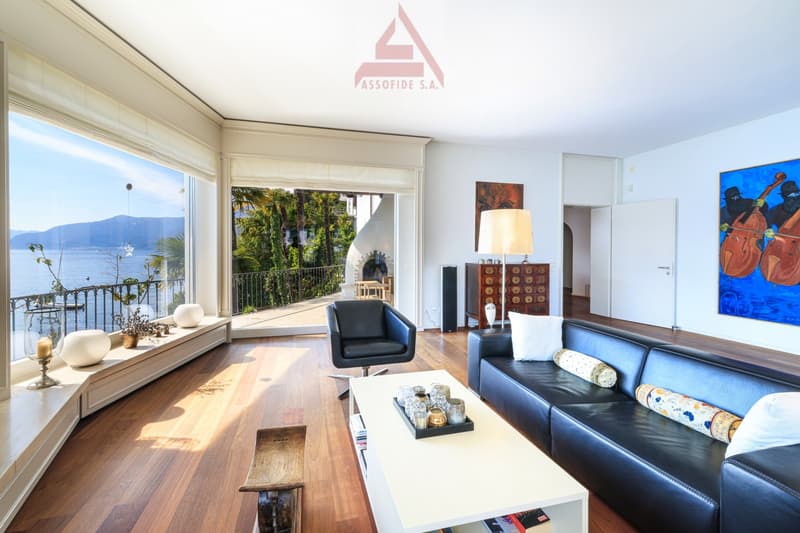 large windows, balcony, black leather sofa, white coffee table, decorative items, painting
