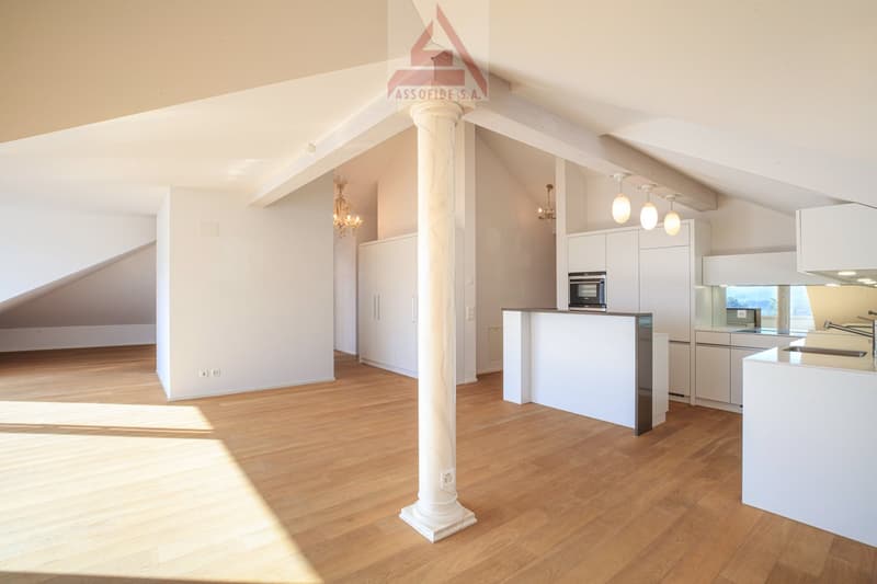 modern kitchen with white cabinets, wooden floor, central column, chandeliers, microwave, sink, faucet