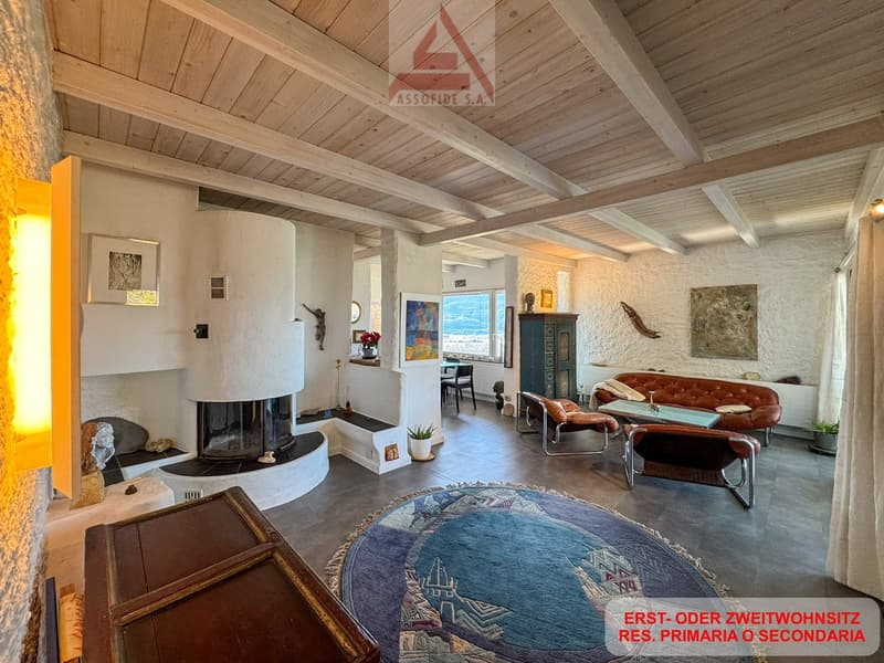 wooden ceiling, fireplace, large windows, couch, armchairs, rug, side table, artwork