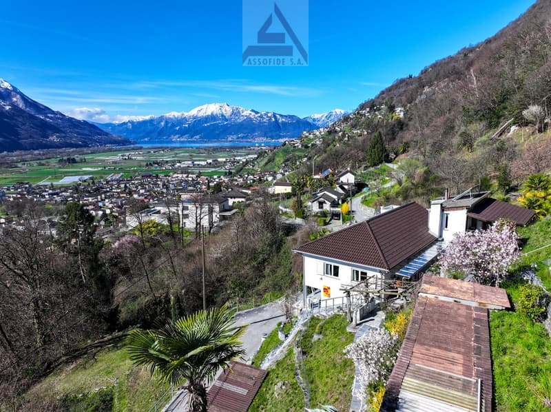 House on a hillside with a view of the mountains and the lake