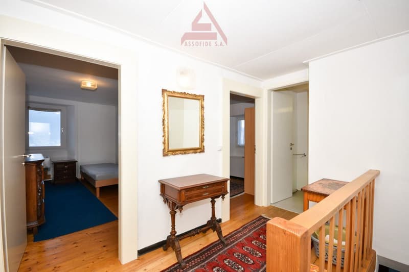 wooden floor, white walls, wooden desk, mirror, blue carpet, wooden bed, wooden cabinet, wooden staircase